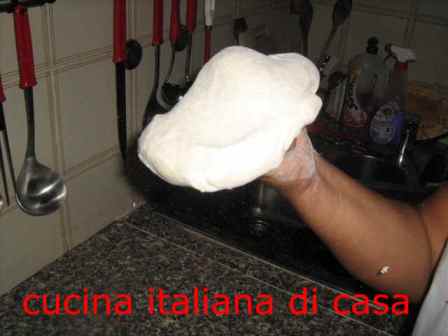 tirae la pizza a mano, come i pizzaioli